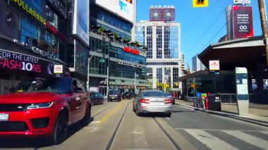 Sürücü bakış açısı gün boyunca şehir merkezinden geçiyor. Uzun Binalar ve Yayalar Boyunca Araç Sür Taşımacılık Seyahati.