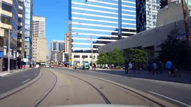 昼間の中心街をドライブする運転者の視点 通りに沿って車を運転する高層ビルや歩行者輸送旅行 — ストック動画