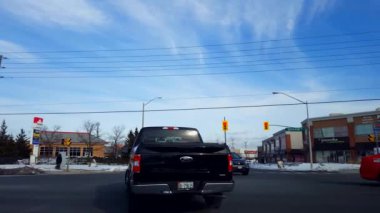 Şehir Kenar Mahalle Kavşağı 'ndan sola dön. Sür Araç Dönüşü Perakende mağazaları ve trafik ile çevrili.