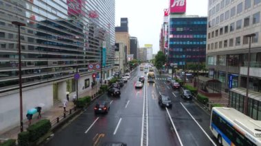 YOKOHAMA, JAPONYA - 17 Ekim 2021: Yağmurlu bir günde Yokohama İstasyonu 'nun yanına taşınan trafik ve yayalar. 