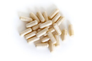 A pile of vitamin capsules from above isolated on white background