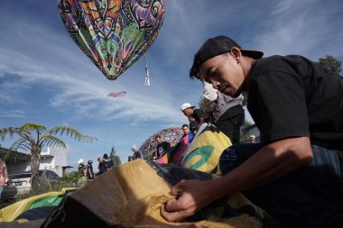 Bromo, Endonezya. Haziran 2022 sıcak hava balonları Bromo Dağı 'nın güneşli gökyüzünü süslüyor. Tipik bir Wonosobo sanatı, Central Java. Batik süslemeli plastik ve tipik Endonezya resimlerinden yapılmıştır.