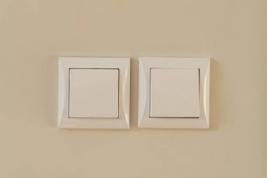 Krem rengi bir duvarda beyaz bir ışık düğmesi