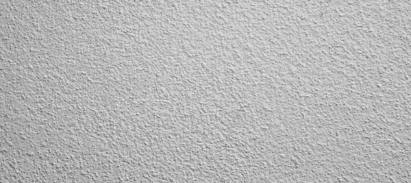 Duvar gri boyayla boyanmış, görünür bir dokusu var.