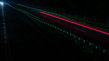 Geceleri hareket halindeki arabaların ışıkları. uzun pozlama