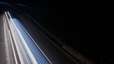 Geceleri hareket halindeki arabaların ışıkları. uzun pozlama