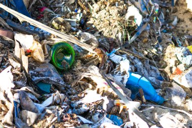 Vahşi çöp yığını. Kalan camlar, ormandaki plastikler.