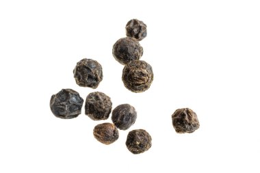 Beyaz zemin üzerinde görünür bir dokusu olan siyah biberler.