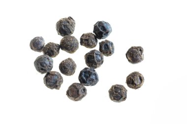 Beyaz zemin üzerinde görünür bir dokusu olan siyah biberler.