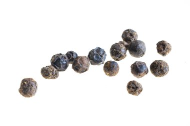 Beyaz zemin üzerinde görünür bir dokusu olan siyah biberler.