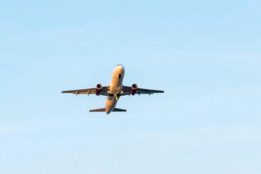 Uçak mavi gökyüzünün arka planında havalanıyor.