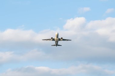 Uçak mavi gökyüzünün arka planında havalanıyor.