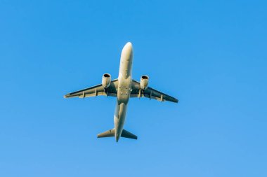 Uçak mavi gökyüzünün arka planında havalanıyor.