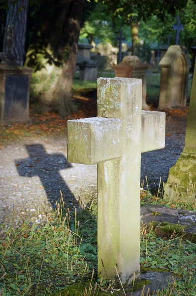 Ancient cemetery with a cross in the evening sun — Stock Photo, Image