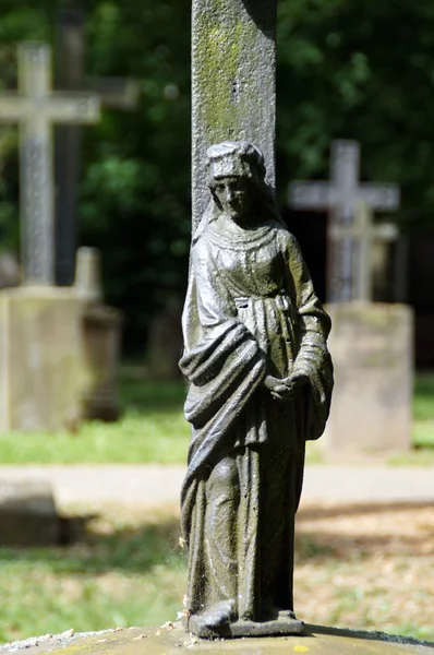 Могильний камінь з виснаженою статуєю Марії — стокове фото