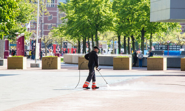 Человек очищает улицу перед музеем
