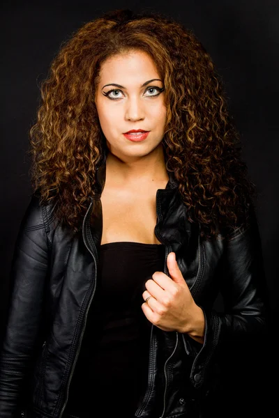 Woman with curly hair posing in a leather jacket — Stock Photo, Image