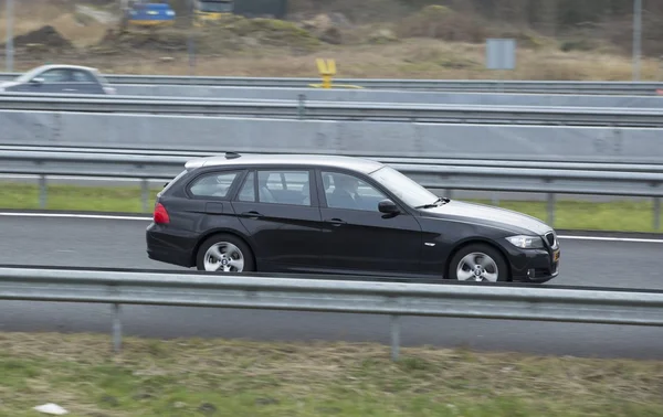 BMW 3 touring jazda w dół drogiBMW 3 touring dirigindo pela estrada — Zdjęcie stockowe