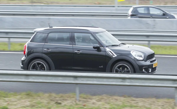 Mini Cooper driving down the road — Stock Photo, Image