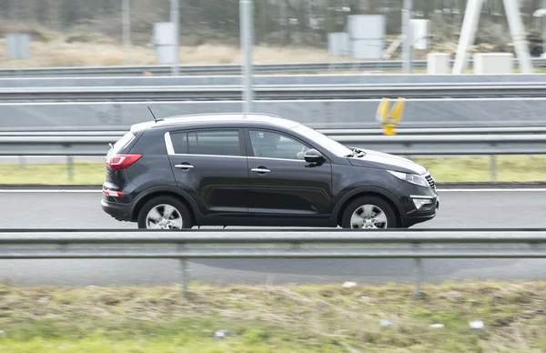 Kia Sportage driving down the road — Stock Photo, Image