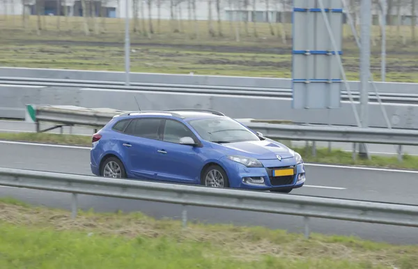 Bleu Renault Megane driving down the road — Stock Photo, Image