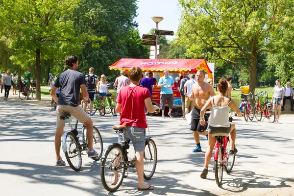 Turistas en alquiler de bicicletas a través de Amsterdam —  Fotos de Stock