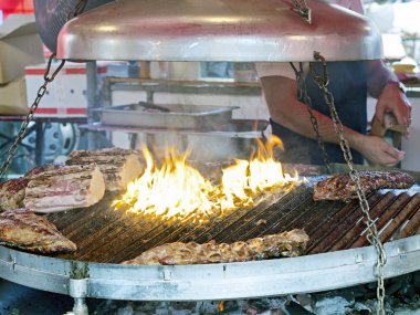 adding salt on roasted meat in large brazier clipart