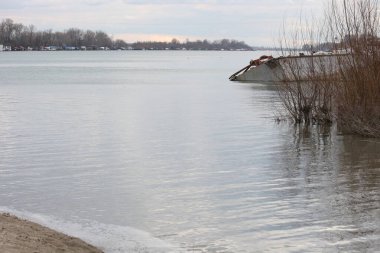 Baharın başında kum ve gemi enkazı olan bir nehirde kumsal..