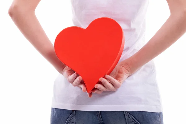 Girl holding heart behind back — Stock Photo, Image