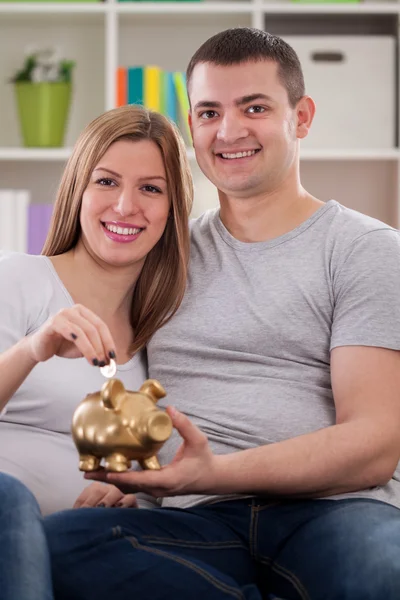 Lachende paar zetten munt — Stockfoto