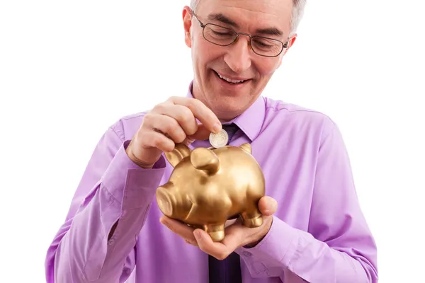 Man putting coin into piggy bank — Stock Photo, Image