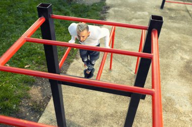 Yatay merdiven konseptinden görülebilen paralel parmaklıklara dalan genç yakışıklı adam.