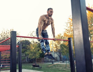 Gömleksiz, yakışıklı bir adam dışarıda çalışıyor. Sadece bir bar kullanıyor. Sağlıklı yaşam tarzı kavramı. 