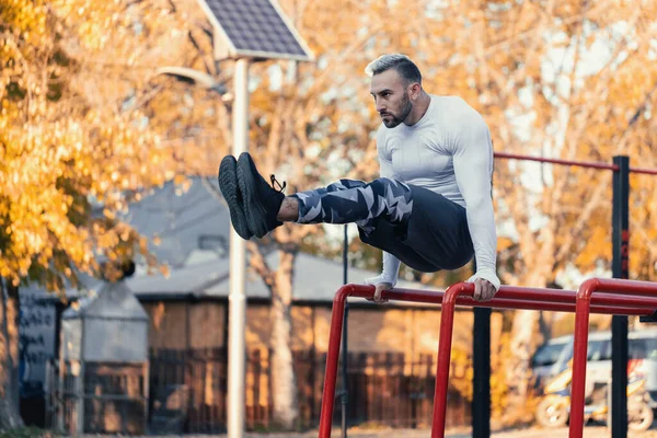 Hombre Muscular Golpeando Los Abdominales Frontales Barras Paralelas Fuera Del —  Fotos de Stock