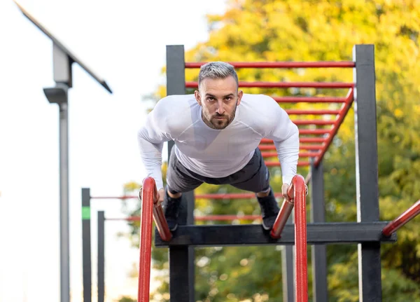 Joven Hombre Musculoso Bien Parecido Haciendo Flexiones Aire Libre Barras —  Fotos de Stock