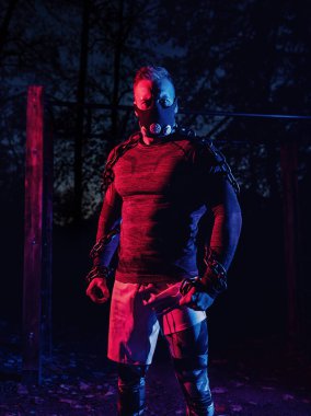 Spor maskesiyle güçlü kaslı bir atlet ve halter zincirleriyle parkta gece boyunca vücut eğitimi, fonksiyonel egzersiz, mahalle konseptinde sokak çalışması