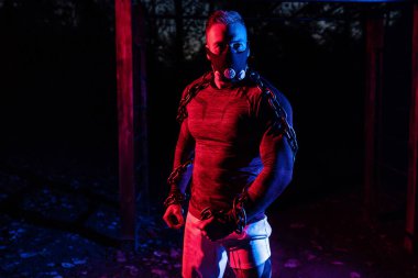 Spor maskesiyle güçlü kaslı bir atlet ve halter zincirleriyle parkta gece boyunca vücut eğitimi, fonksiyonel egzersiz, mahalle konseptinde sokak çalışması