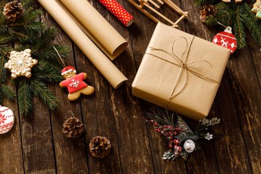 Zencefilli Noel Baba ve kar tanesi ev yapımı Noel kurabiyesi şeklindeki Noel kurabiyesinin yanında ahşap masa arkaplanında her zaman yeşil dalları olan bir hediye. Tatil kavramı.