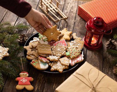 Bir tabak dolusu ev yapımı kurabiye ve bisküvi. Geleneksel Noel ve yeni yıl teması şeklinde. Ahşap bir masaya yerleştirilmiş, mutlu bayramlar kavramı.