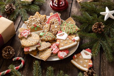 Lezzetli kış kurabiyeleri, Noel motifleri şeklinde ev yapımı bisküviler, şekerli fırında zencefilli kurabiyeler, zencefilli Noel Baba, her zaman yeşil ve kırsal ahşap arka plan konsepti.
