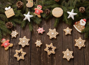 Lezzetli ev yapımı şenlikli Noel kurabiyeleri kış tatili motifleri ahşap arka planda kozalaklı ağaç dalları, kış tatili konsepti