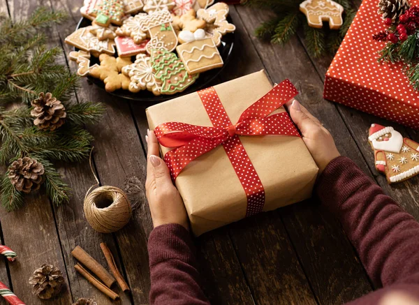 Tangan Memegang Hadiah Natal Indah Dihiasi Dan Dibungkus Atas Meja — Stok Foto