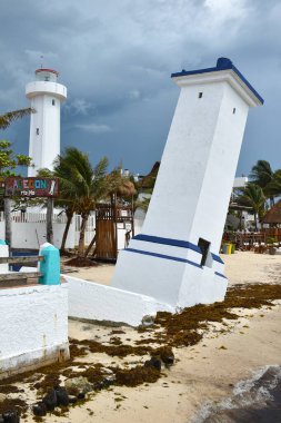 Puerto Morelos 'ta, Meksika' daki Yucatan Yarımadası 'ndaki Malecon ahşap iskelesinde eğilmiş Faro Inclinado deniz feneri..