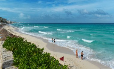 Cancun, Meksika - 11 Eylül 2021: Kumsal, sahil ve turkuaz deniz, büyük dalgalar, denize giren insanlar, Karayipler, Cancun, Yucatan, Meksika