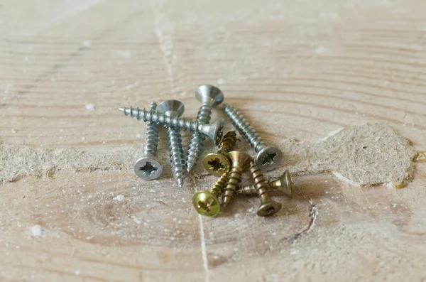 Set of screws on the grunge wood background — Stock Photo, Image