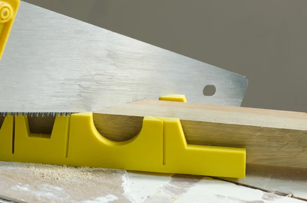 Saw cutting the wooden bar, using yellow guides — Stock Photo, Image