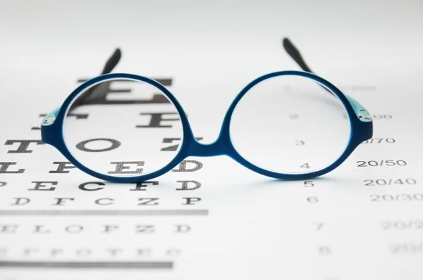 Glasses on eye chart — Stock Photo, Image