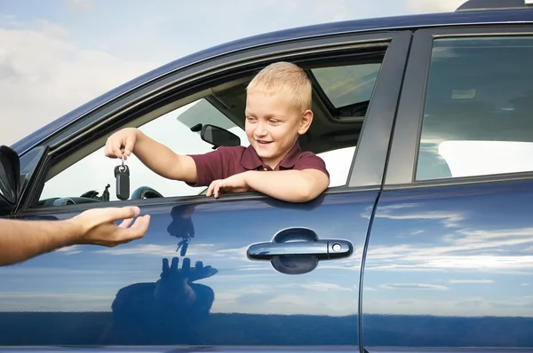 Lyckligt barn visar nycklar från bil Stockbild