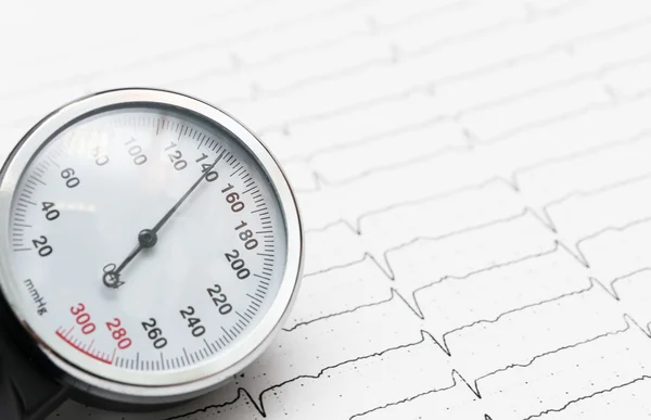 Sphygmomanometer on the cardiogram — Stock Photo, Image