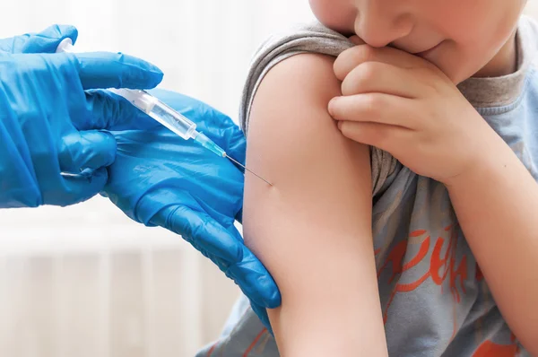 Junge und Impfspritze Stockbild